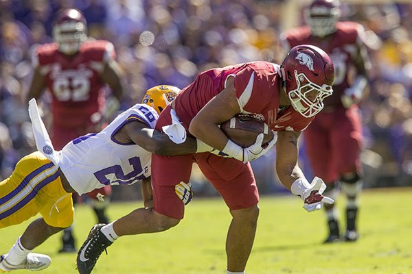 Arkansas tight end Jeremy Patton tries to break the tackle of LSU defender John Battle during a game Saturday, Nov. 11, 2017, in Baton Rouge, La. 