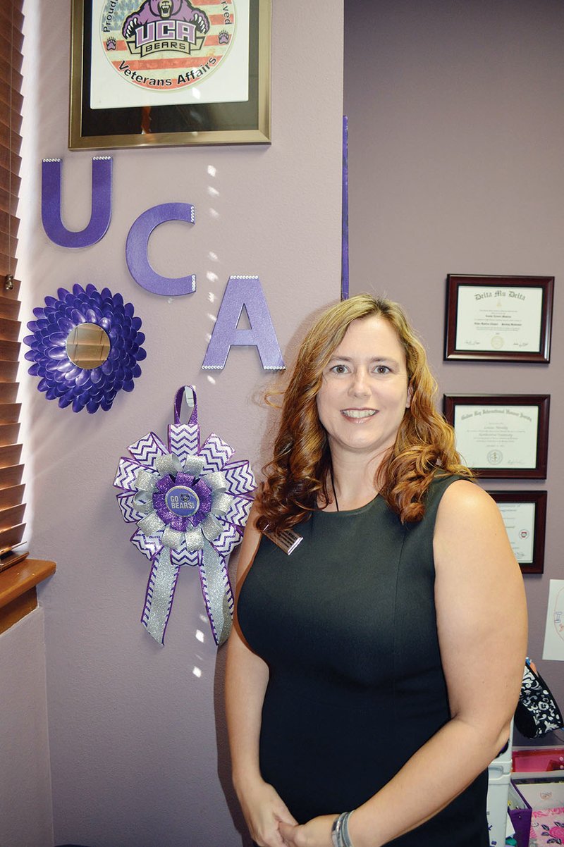Louisa Moseley, 38, stands in her office in the Academic Advising Center at the University of Central Arkansas in Conway. Moseley, a mother of five, was named Woman of the Year by the Conway Business and Professional Women chapter. She recently earned a doctorate in organizational leadership.