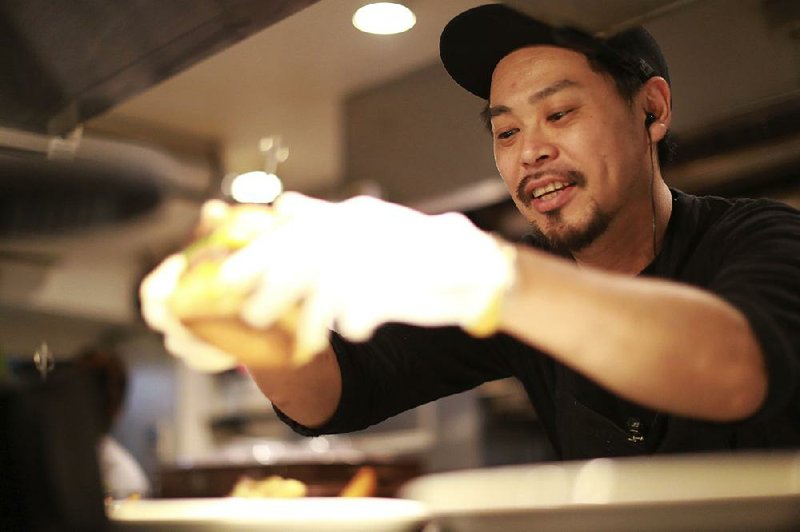 Yutaka Yanagisawa, owner of Munch’s Burger Shack restaurant, prepares a burger at his restaurant in Tokyo last week. 
