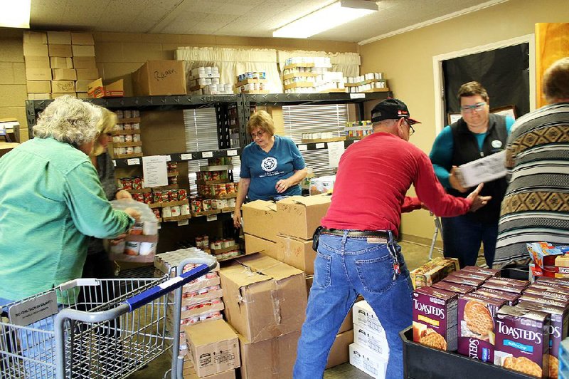 Volunteers and staff at the Conway Ministry Center’s Storehouse Client Choice Pantry in Conway unload food from donated shopping carts and sort them for distribution to area families.  