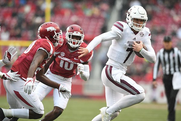 Mississippi State quarterback Nick Fitzgerald (7) is chased by Arkansas defenders during a game Saturday, Nov. 18, 2017, in Fayetteville. 