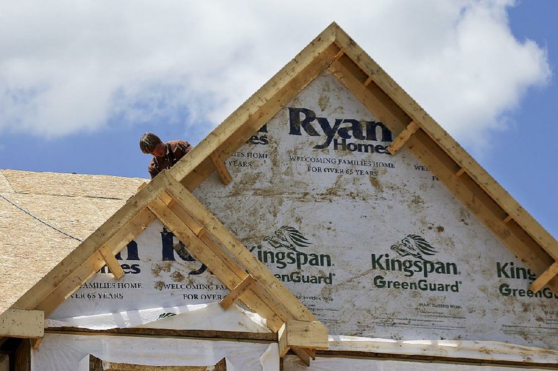 Workers install a roof on a home going up earlier this year in Jackson Township, Pa. The rise in home construction in October was the biggest in a year.