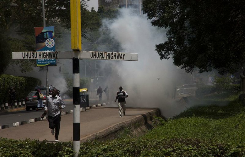People run away Friday as police in Nairobi, Kenya, fire tear gas at supporters of opposition leader Raila Odinga. 