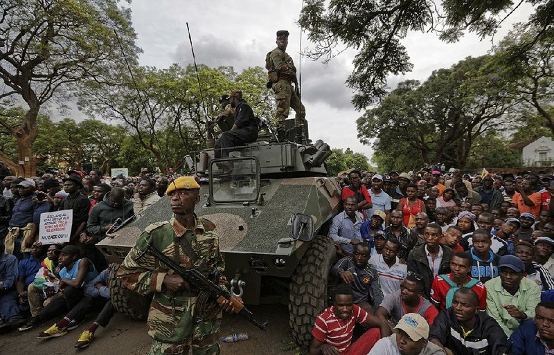 Demonstrators surround a Zimbabwean military armored vehicle Saturday in Harare as they call for the resignation of President Robert Mugabe.