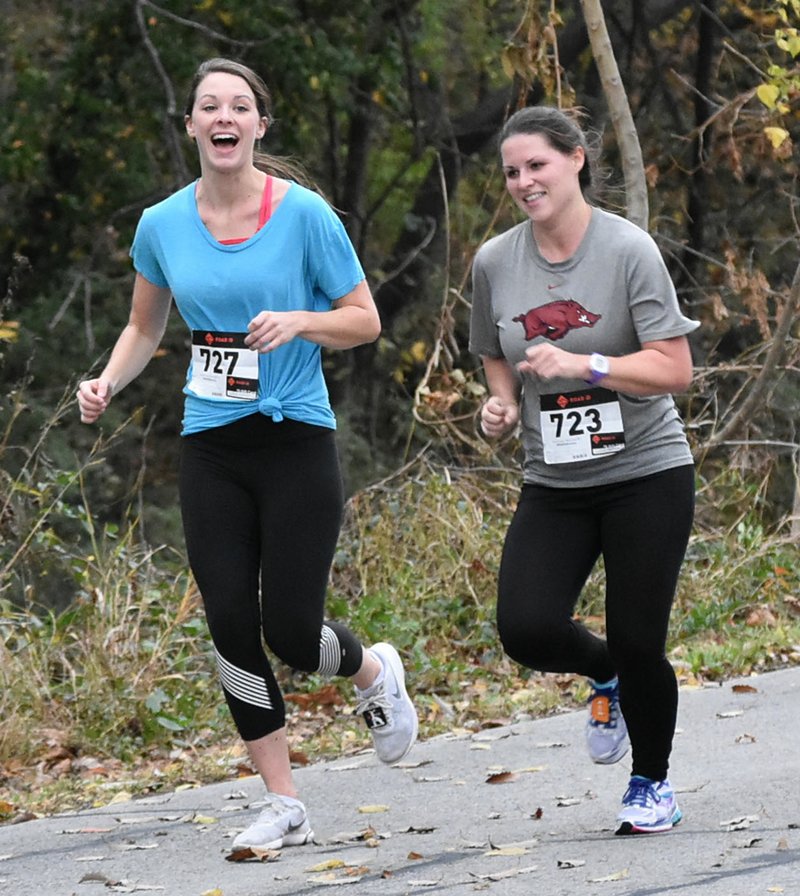 Mike Capshaw/Siloam Sunday Karyn Telce, left, and Kendra Stokes were all smiles as they approached the finish line of the 2017 Turkey Trot 5K Run on Saturday morning.