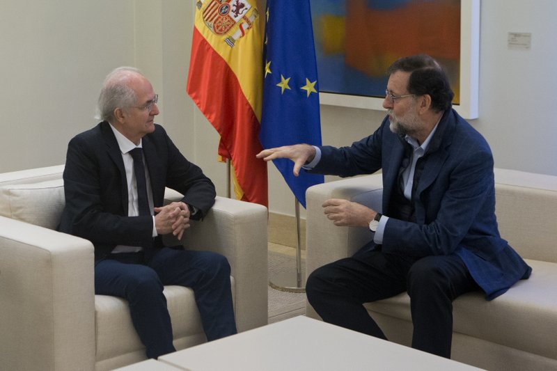 Former Caracas Mayor Antonio Ledezma, left, sits with Spain's Prime Minister Mariano Rajoy during a meeting at the Moncloa Palace in Madrid, Spain, Saturday, Nov. 18, 2017. The ousted mayor of Caracas pledged to spread his protest against Venezuela's socialist government across the world as he arrived in Spain on Saturday, a day after escaping from house arrest and slipping past security forces into Colombia. (AP Photo/Paul White)