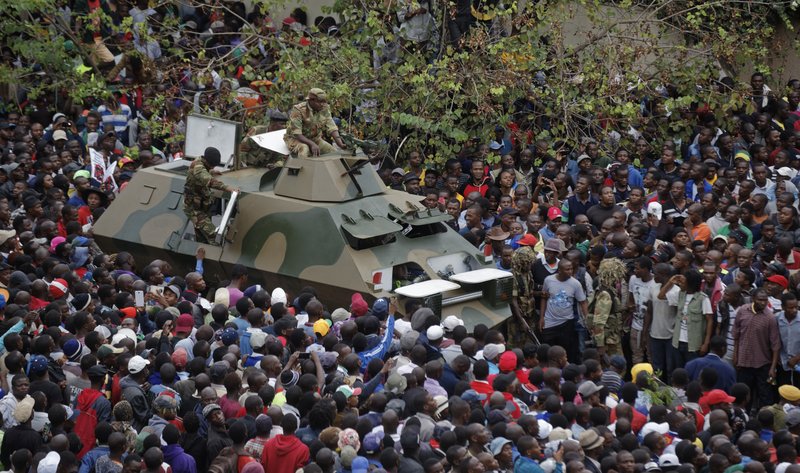 The Associated Press CROWD: An army armored personnel carrier drives slowly through the gathered crowd of thousands demanding President Robert Mugabe stand down, on the road leading to State House Saturday in Harare, Zimbabwe. In a euphoric gathering that just days ago would have drawn a police crackdown, crowds marched through Zimbabwe's capital to demand the departure of Mugabe, one of Africa's last remaining liberation leaders, after nearly four decades in power.