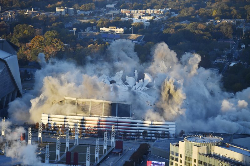 The Georgia Dome is destroyed in a scheduled implosion next to its replacement the Mercedes-Benz Stadium, left, Monday, Nov. 20, 2017, in Atlanta. The dome was not only the former home of the Atlanta Falcons but also the site of two Super Bowls, 1996 Olympics Games events and NCAA basketball tournaments among other major events. (AP Photo/Mike Stewart)
