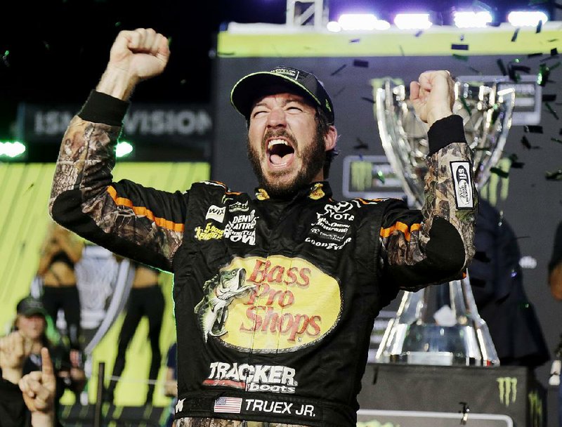 Martin Truex Jr. shouts in jubilation after climbing from his car in Victory Lane at Homestead-Miami Speedway on Sunday. Truex won the Ford Ecoboost 400 and claimed his fi rst NASCAR Monster Energy Cup Series season championship.