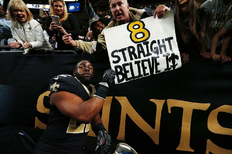 New Orleans Saints running back Mark Ingram celebrates with fans after the Saints’ 34-31 overtime victory over the Washington Redskins on Sunday. The Saints trailed by 15 points with less than 3 minutes remaining but rallied for their eighth consecutive victory.