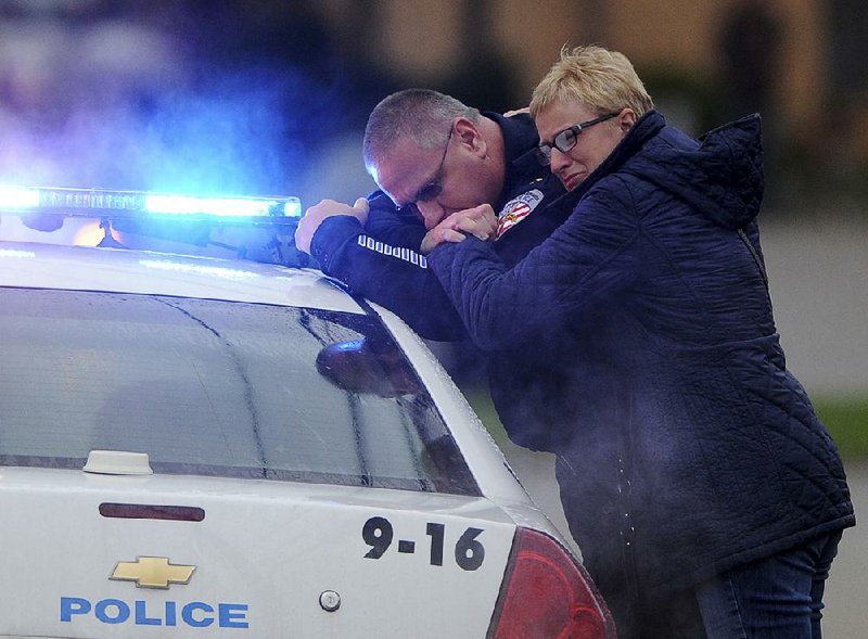 New Kensington, Pa., Police Chief James Klein and Lisa Shaw, mother of slain officer Brian Shaw, grieve Saturday while waiting for a procession carrying Brian Shaw’s body to arrive in Lower Burrell.