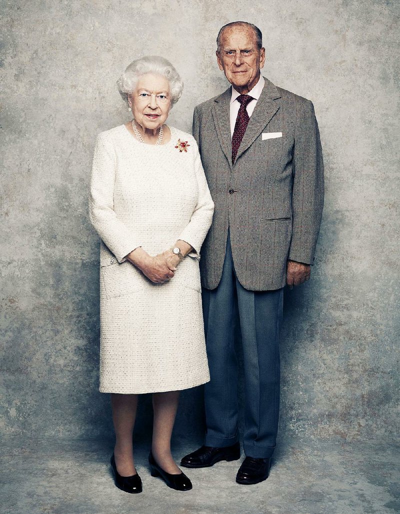 In this handout photo issued by Camera Press and taken in Nov. 2017, Britain's Queen Elizabeth and Prince Philip pose for a photograph in the White Drawing Room pictured against a platinum-textured backdrop at Windsor Castle, England. 