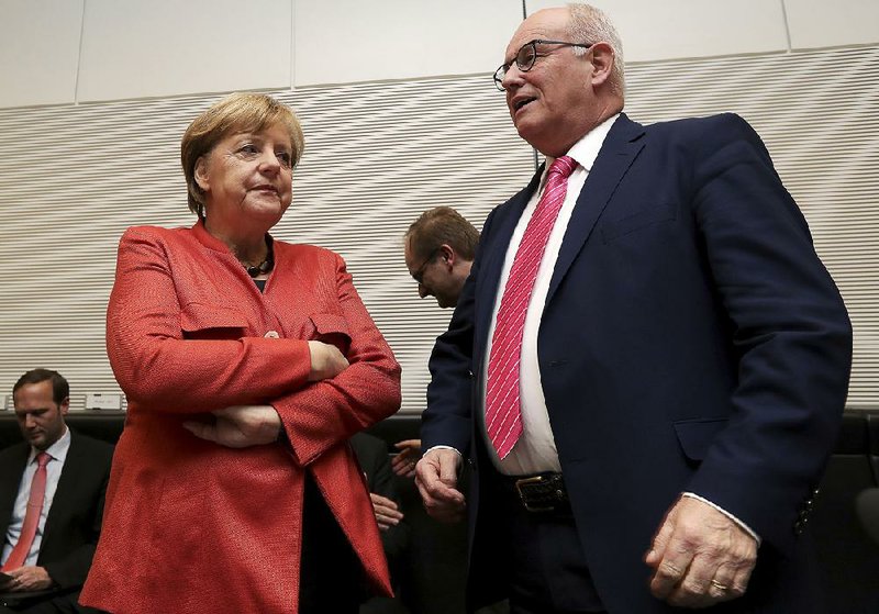 German Chancellor Angela Merkel  talks with Volker Kauder, faction leader of Merkel’s Christian Democratic Union party, before a meeting Monday in Berlin.