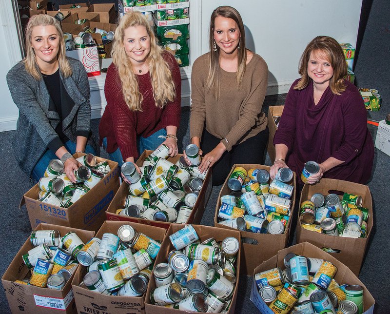 The Junior Auxiliary of Searcy sponsored its annual Food Basket Project to help local families with their Thanksgiving meals. Helping to sort more than 2,000 canned food items collected by students in the Searcy School District are Jessie Hohenstein of Searcy, from left, co-chairwoman of the Angel Tree Project and chairwoman of The Sunshine School Project and the Covering Kids Project; Ashley Fulks of Searcy, chairwoman of the Food Basket Project and pubic relations chairwoman for the organization; Morgan George of Searcy, treasurer; and Natalie Horton of Searcy, president.