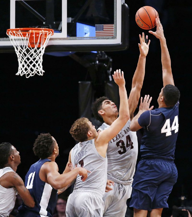 Penn State forward Julian Moore (44) shoots over Texas A&M’s D.J. Hogg (1) and Tyler Davis (34) during the Aggies’ 98-87 victory in the Legends Classic in New York. 