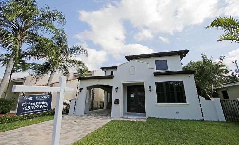 A house is posted for sale in Coral Gables, Fla., in this December file photo. The National Association of Realtors reported that home sales in October rose 2 percent. 

