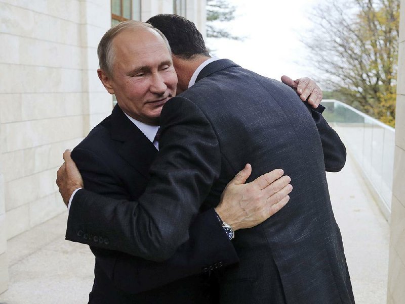 Russian President Vladimir Putin (left) gets an embrace Monday from Syrian President Bashar Assad at the Black Sea resort town of Sochi, Russia, after talks about a new peace initiative drafted by Russia, Turkey and Iran. Putin and President Donald Trump later discussed the plan in an hour-plus phone call.  