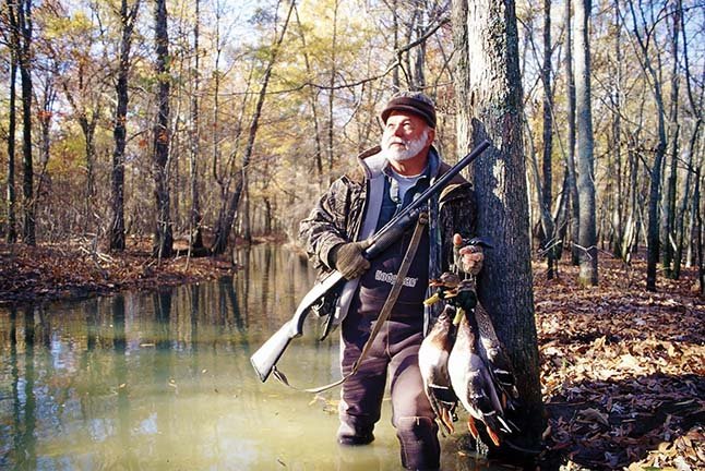 Sammie Faulk of Lake Charles, La., watches for ducks in flooded timber near Humnoke. Arkansas’ blue-ribbon timber hunting attracts waterfowlers from throughout the world.