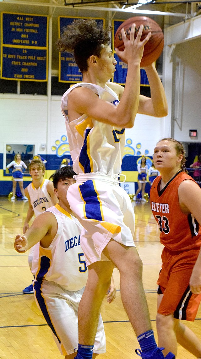 Photo by Mike Eckels Decatur's Garry Woods (center) pulled down a rebound midway through the first quarter of the Decatur-Exeter senior basketball contest at Peterson Gym in Decatur on Friday. The Bulldogs defeated the Tigers, 76-56, in the first home game of the season.