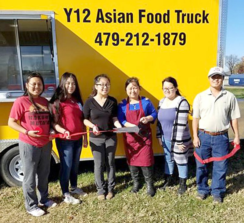 Submitted Photo A Gentry chamber-sponsored ribbon cutting was also held on Thursday, Nov. 16, at the Y12 Asian Food truck, usually parked just south of the Little Debbie Store on Arkansas Highway 59 in Gentry. Crystal Vang is the owner and her number is 479-212-1879 for more information or to order. Pictured with Crystal Vang (center, in red apron) are her husband Alex Yang and daughters Florine, Natalie, Amanda and Melonie Yang.