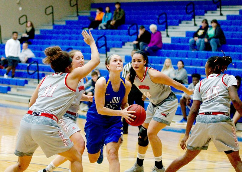 Photo courtesy of JBU Sports Information John Brown sophomore guard Jordan Martin drives through four MidAmerica Nazarene (Kan.) defenders during Saturday's game at Bill George Arena. The Pioneers defeated the Golden Eagles 58-49.