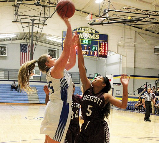 The Sentinel-Record/Mandie Gober UP AND OVER: Makayla Wilson scores Tuesday against the Prescott Curly Wolves at the Lakeside Athletic Complex on the final day of the Lakeside Classic tournament. Wilson led the Lady Lions with 11 points.