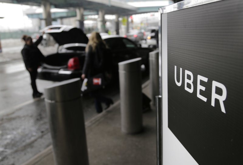In this March 15 file photo, a sign marks a pick-up point for the Uber car service at LaGuardia Airport in New York. Uber is coming clean about its cover-up of a year-old hacking attack that stole personal information about more than 57 million of the beleaguered ride-hailing service's customers and drivers. The revelation Tuesday marks the latest stain on Uber's reputation. (AP Photo/Seth Wenig, File)