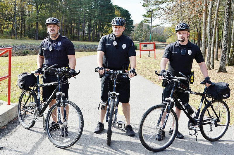 The new Conway Police Department Crime Suppression Unit includes, from left, J.P. Bolling, Todd Wesbecher and Dellwyn Elkins, who are on a walking/biking trail on Salem Road. Not pictured is Lt. Gene Hodges. The officers patrol trails and neighborhoods on their bicycles, as well as answer calls in vehicles. “We don’t like to sit around waiting for a crime to happen before we go do something about it,” Hodges said.