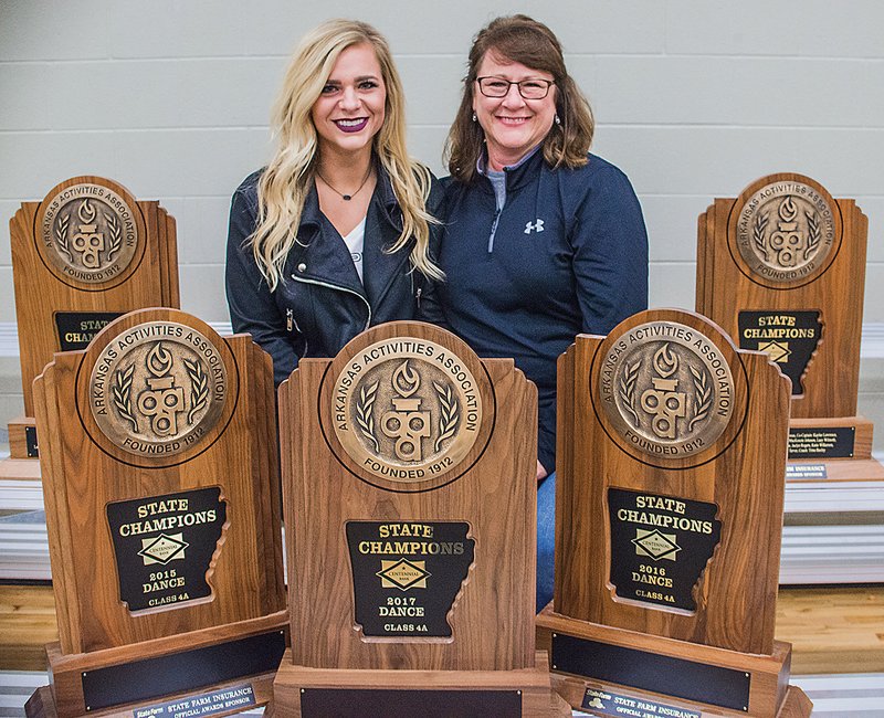 Chelsea Tarver and her mom, Bauxite Lady Miner dance coach Charlotte Tarver, are surrounded by the five state championship trophies they won as head coaches. Chelsea, who currently serves as the team’s choreographer, won the first three championships, beginning in 2013, and Charlotte has won the title the past two.