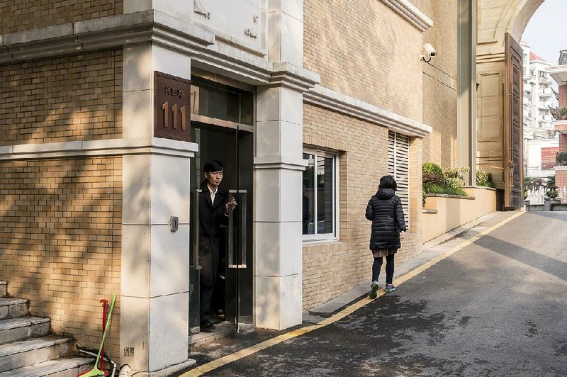 A security guard stands at the entrance to an unmarked building listed as the address for CEFC China Energy Co. in Shanghai on Wednesday. 