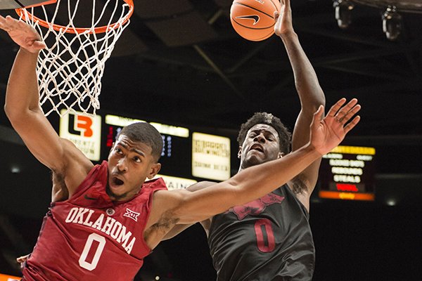 Oklahoma guard Christian James, left, is fouled by Arkansas guard Jaylen Barford, right, on a fast break during the first half of an NCAA college basketball game at the Phil Knight Invitational tournament, in Portland, Ore., Thursday Nov. 23, 2017. (AP Photo/Troy Wayrynen)

