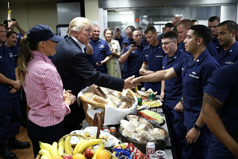 President Donald Trump, with first lady Melania Trump, greets and hands out sandwiches to members of the U.S. Coast Guard, at the Lake Worth Inlet Station, on Thanksgiving, Thursday, Nov. 23, 2017, in Riviera Beach, Fla. 