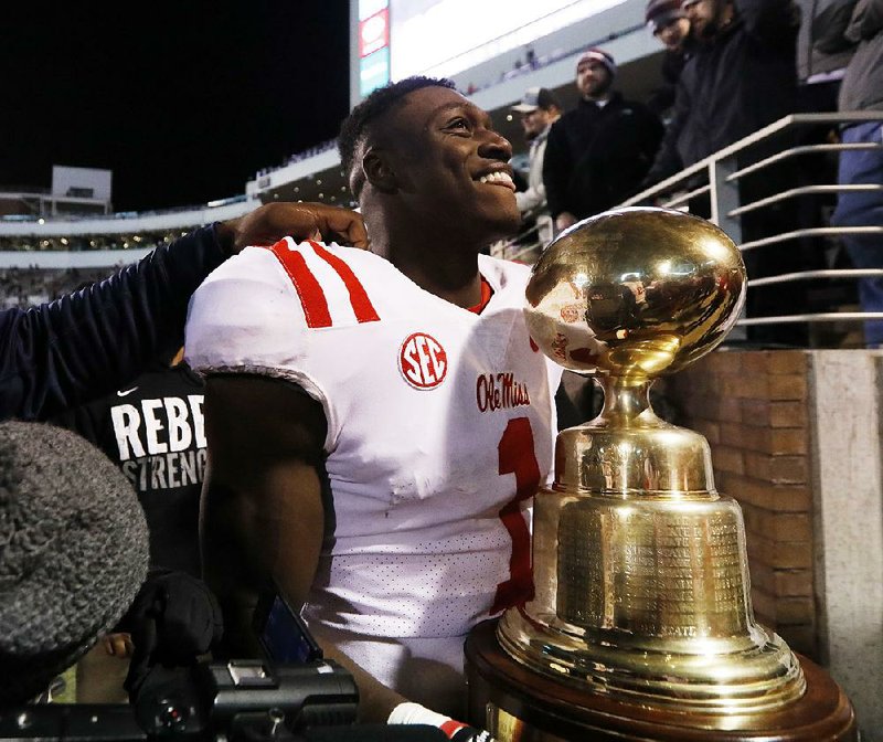 Mississippi’s A.J. Brown celebrates with the Egg Bowl trophy after the Rebels defeated Mississippi State 31-28 on Thursday in Starkville, Miss. 