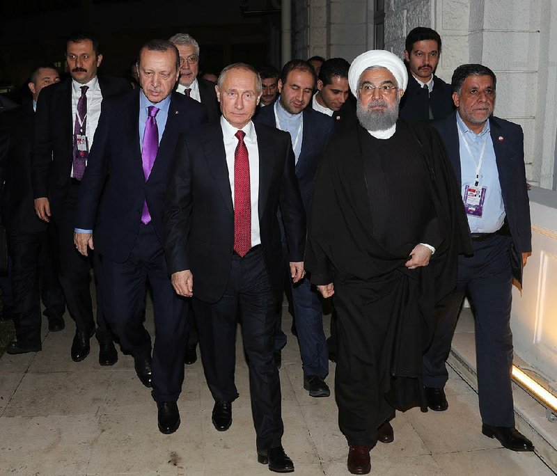 Russian President Vladimir Putin (center), flanked by Turkish President Recep Tayyip Erdogan (left) and Iranian President Hassan Rouhani, leave a news conference Wednesday in the Black Sea port of Sochi, Russia. 