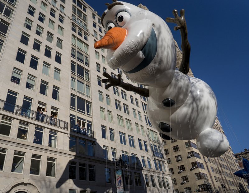 The Associated Press BUILD A SNOWMAN: The Olaf balloon glides over Central Park West on Thursday during the Macy's Thanksgiving Day Parade in New York.