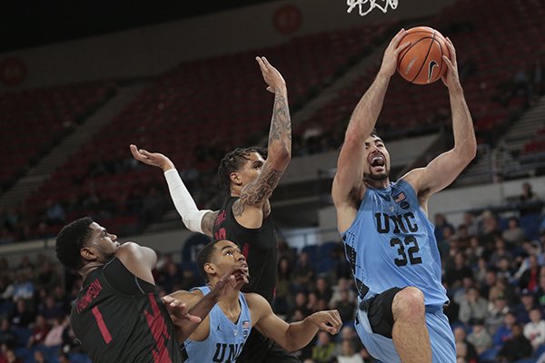 North Carolina's Luke Maye (32) gets past Arkansas' Trey Thompson (1) and Dustin Thomas, center rear, and teammate Garrison Brooks, center, for two points in the first half of an NCAA college basketball game during the Phil Knight Invitational tournament in Portland, Ore., Friday, Nov. 24, 2017. (AP Photo/Timothy J. Gonzalez)

