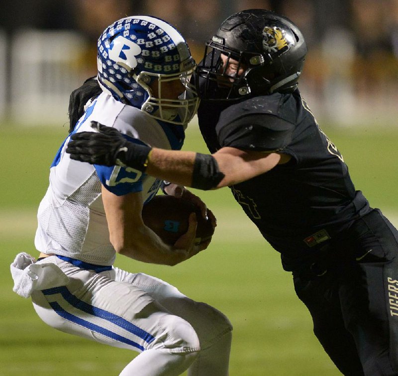 Bentonville linebacker Andrew Griffith (right) sacks Bryant quarterback Ren Hefley on Friday during the first half of the Tigers’ 44-14 victory over the Hornets in the Class 7A state playoff semifinals in Bentonville.