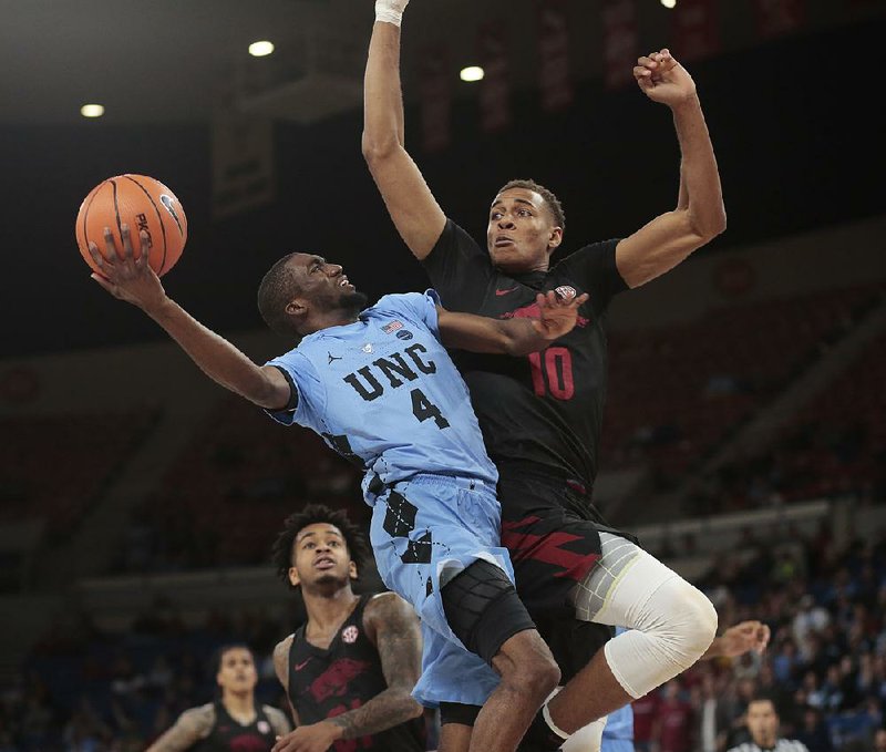Arkansas’ Daniel Gafford (right) defends a shot by North Carolina’s Brandon Robinson during Friday’s game in the Phil Knight Invitational in Portland, Ore.