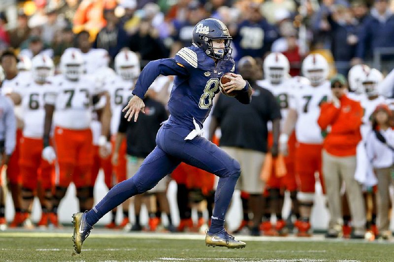 Pittsburgh freshman quarterback Kenny Pickett runs past the Miami bench on his way to a 22-yard touchdown run in the second half Friday in Pittsburgh. Pickett ran for two touchdowns and threw for another as Pittsburgh upset No. 2 Miami 24-14. 
