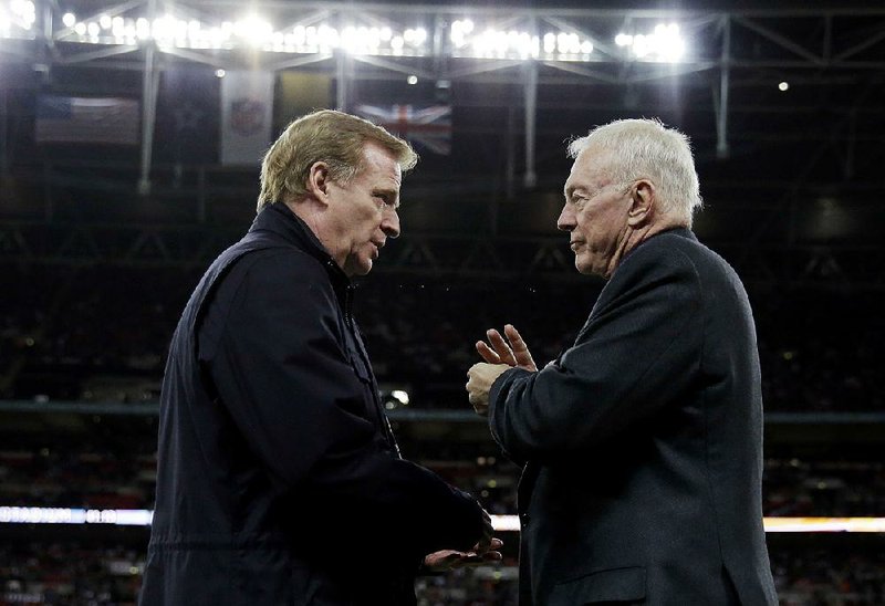 NFL Commissioner Roger Goodell (left) and Dallas Cowboys owner Jerry Jones talk during a Cowboys game in 2014 at Wembley Stadium in London. Jones confirmed he is backing off a threat of legal action over the future of Goodell. 
