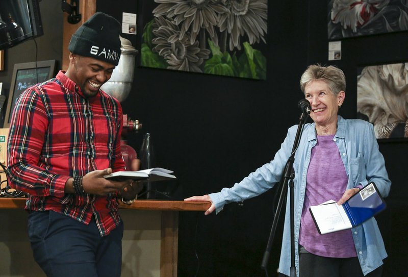 Karen Hayes jokes with Gamma, a poet from Little Rock, while introducing him to the crowd during open mic night at Guillermo’s Coffee, Tea and Roastery in Little Rock on Nov. 9. Hayes gained a newfound love of poetry after her husband was diagnosed with Alzheimer’s several years ago.