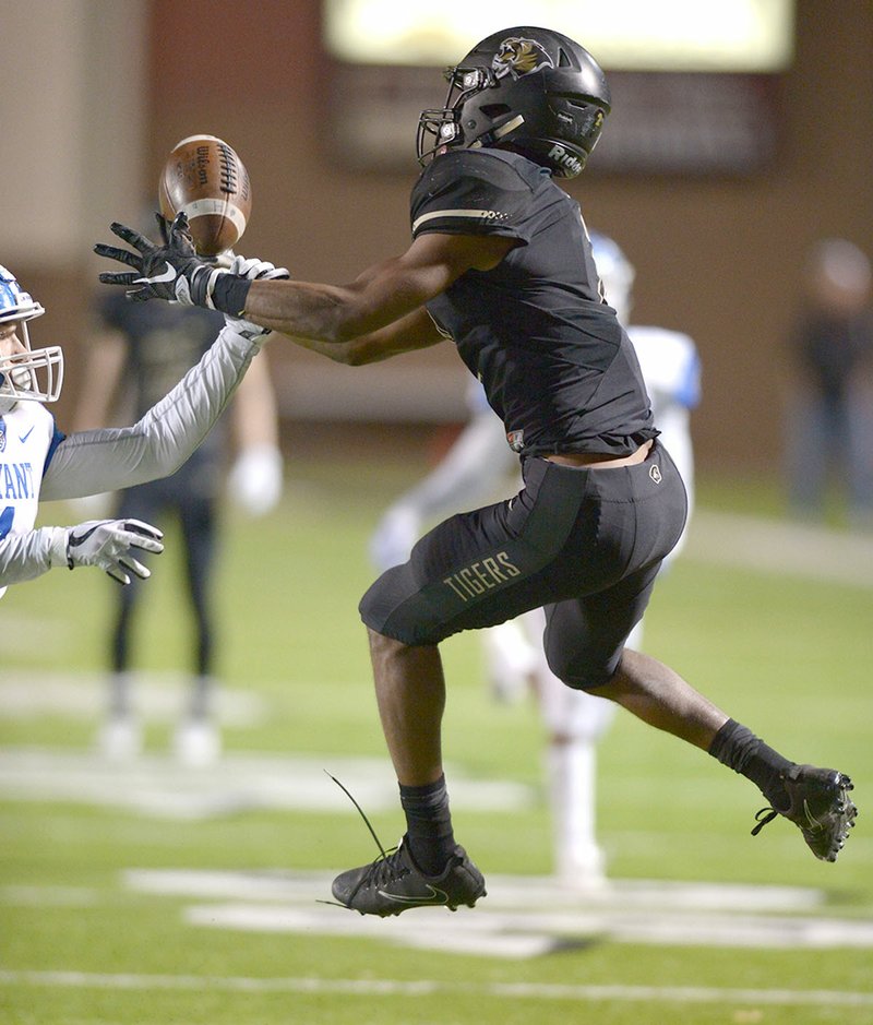 NWA Democrat-Gazette/ANDY SHUPE Bentonville High receiver Kam'ron Mays-Hunt reels in a pass despite close coverage from Bryant safety Cameron Vail on Friday in Bentonville.