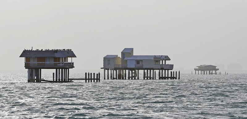 This photo taken Saturday, Oct. 21, 2017, shows some of the half-dozen getaway shacks that seem to float over Biscayne Bay a mile from the Florida coast in Miami. Stiltsville survived Hurricane Andrew in 1992, but they might have finally fallen into the water in September if Hurricane Irma had not swerved into the Florida Keys instead of downtown Miami. (AP Photo/Alan Diaz)