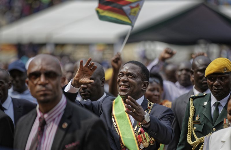 The Associated Press ZIMBABWE: Zimbabwe's President Emmerson Mnangagwa, center, gestures to the cheering crowd as he leaves after the presidential inauguration ceremony Friday in the capital Harare, Zimbabwe. Mnangagwa was sworn in as Zimbabwe's president after Robert Mugabe resigned on Tuesday, ending his 37-year rule.