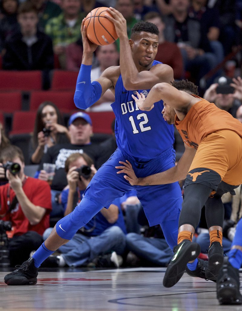 The Associated Press TAKING IT HOME: Duke forward Javin DeLaurier drives to the basket past Texas guard Eric Davis Jr. during the first half of an NCAA basketball game in the Phil Knight Invitational tournament in Portland, Ore., Friday.