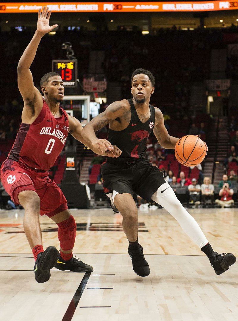Arkansas guard Daryl Macon drives to the basket as he is guarded by Oklahoma guard Christian James during the second half Thursday at the Phil Knight Invitational in Portland, Ore. Macon, the team’s second-leading scorer at 16.4 points per game, suffered a right ankle injury during Friday’s loss to North Carolina.