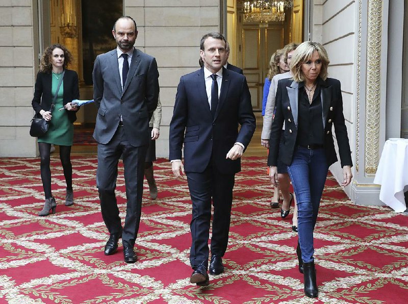 French President Emmanuel Macron (center) and his wife, Brigitte Macron (right), arrive with Prime Minister Edouard Philippe on Saturday at a Paris ceremony marking the International Day for the Elimination of Violence Against Women. 
