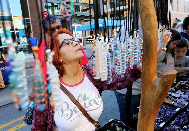 Fanny Salgado looks at crystals on display from a vendor Saturday at the small-business festival in Little Rock’s downtown River Market District. 