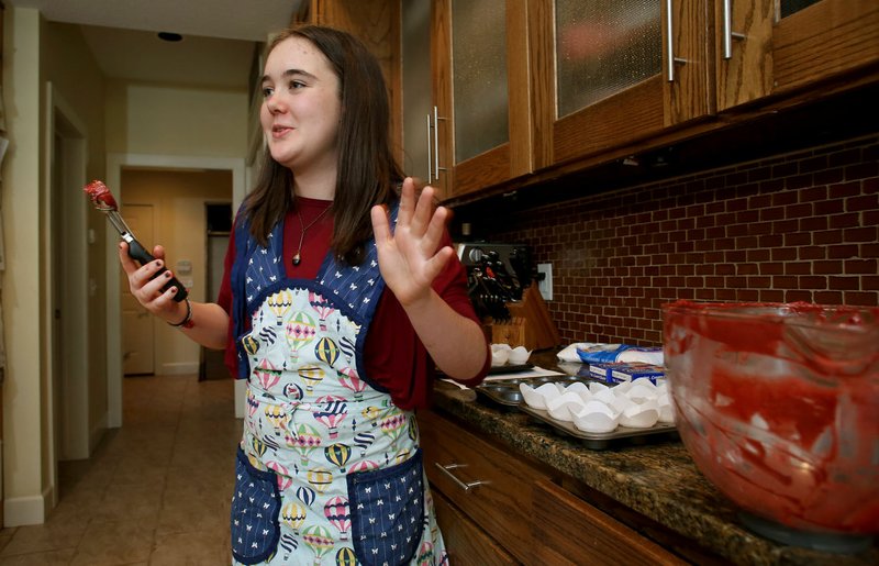 NWA Democrat-Gazette/DAVID GOTTSCHALK Gable Sloan, 12, describes Nov. 16 the importance of her Christmas Tree Art display as she bakes red velvet cupcakes in the kitchen of her family's house in Fayetteville. Gable hopes the display, which will move to different businesses during the holiday season, will help bring attention to the issue of student homelessness. Gable operates Gable's Bakery, a nonprofit bakery and catering business.