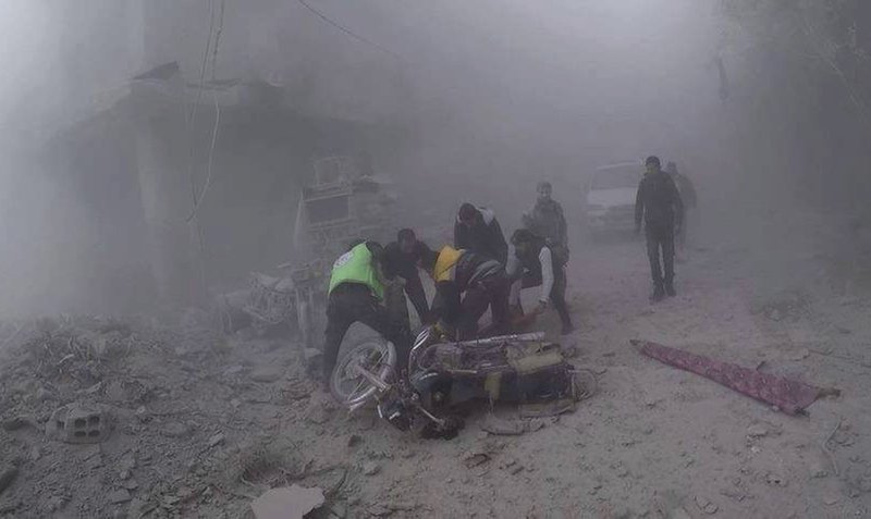 In this photo provided by the Syrian Civil Defense group in Damascus suburbs known as the White Helmets, Civil Defense workers carry an injured man after government airstrikes hit Douma, near Damascus, Syria, Sunday Nov. 26, 2017. Government airstrikes and shelling outside the Syrian capital killed at least 22 civilians, activists reported Sunday, as the fighting showed no signs of letting up ahead of the resumption of U.N. peace talks in Geneva. (Syrian Civil Defense in Damascus suburbs via AP)